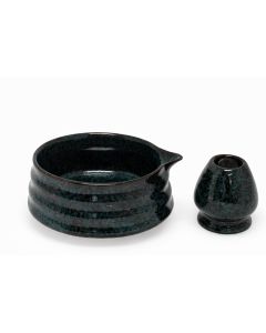 Matcha kom met schenktuit en bijpassende houder van keramiek in donker groen-zwarte kleur, vrijstaand tegen witte achtergrond.