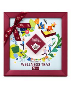 English Tea Shop Wellness Teas geschenkdoos met 32 biologische theezakjes, bordeauxrode strik en kleurrijke botanische illustraties.