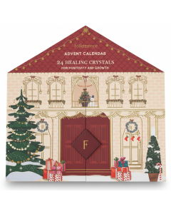 Close-up van de Folkessence healing crystals adventskalender met rode dakprint en kerstdecoraties.