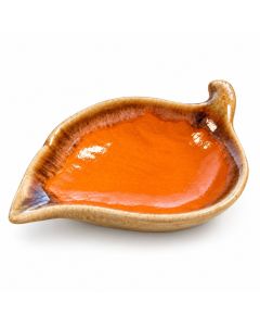 Keramieken bladschaaltje met een glanzend oranje binnenkant, een gespikkelde beige rand en bruine kleurnuances, gefotografeerd op een witte achtergrond.
