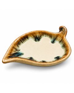 Keramieken bladschaaltje in crèmewit en bruin met blauwgroene glazuuraccenten, een glanzende afwerking en een organische bladvorm op een witte achtergrond.