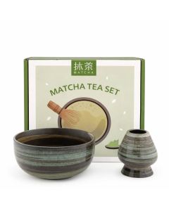 Matcha set met ronde keramieken matcha kom en gardehouder in bruin-goene aardetinten, gepresenteerd in geschenkdoos