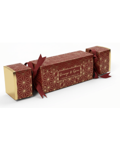 Schuin aanzicht van de Orange & Spice sojakaarsen gift cracker met rood-gouden patroon en strikdetails.