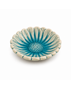 Blauw keramieken schaaltje in de vorm van een zonnebloem, met crèmekleurige bloemblaadjes, een gedetailleerd bloemhart en glanzend glazuur op een witte achtergrond.